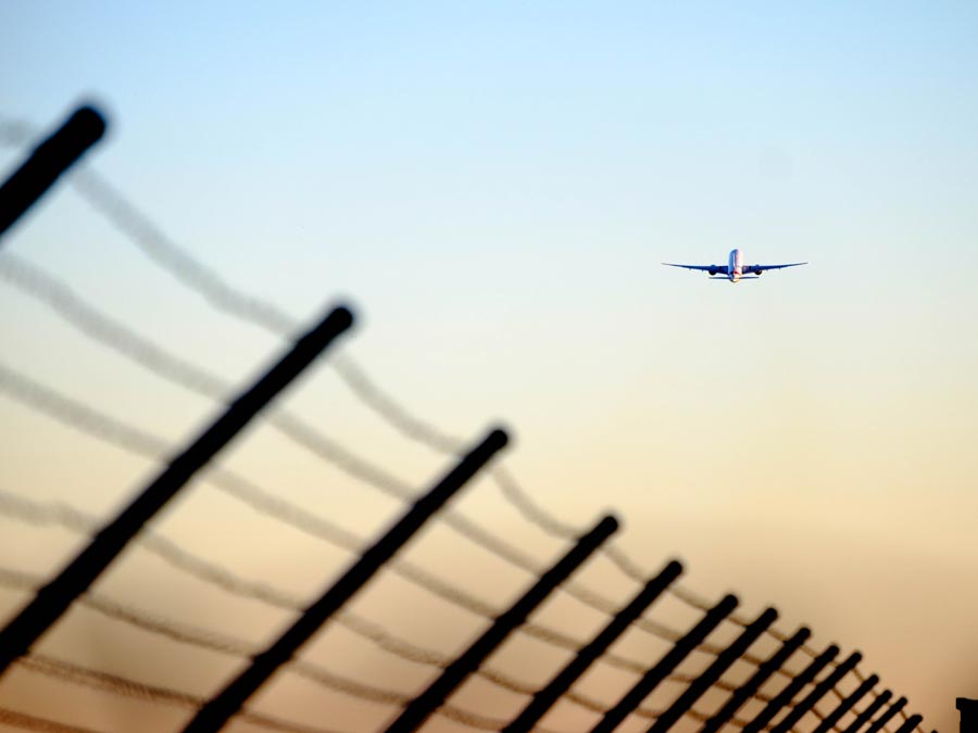 airplane flying over fence